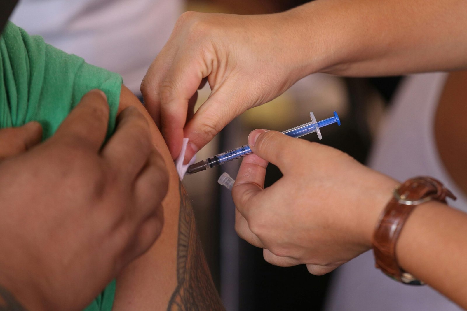 Medical professional giving an injection to a patient, emphasizing health and treatment.